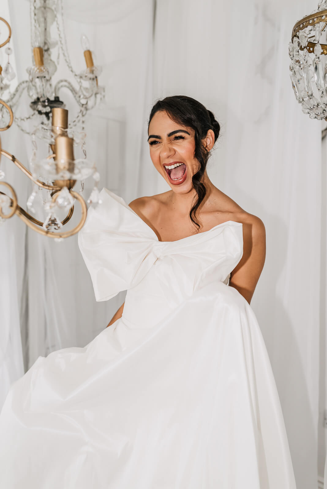 epic modern bridal wear white draping in the background and chandeliers. photo by Sarah Glynn photography who is a liverpool based funky wedding photographer